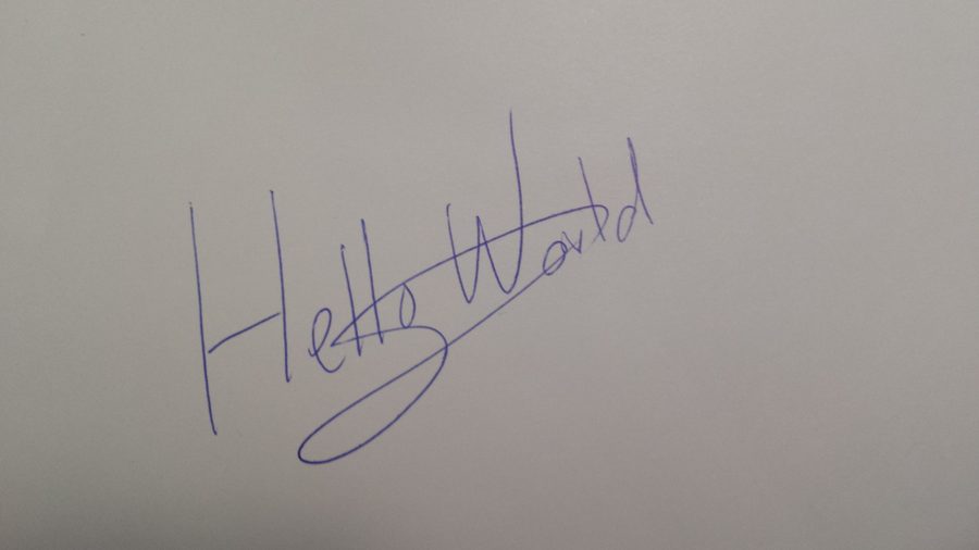 Phone photo of handwritten signature with white paper background